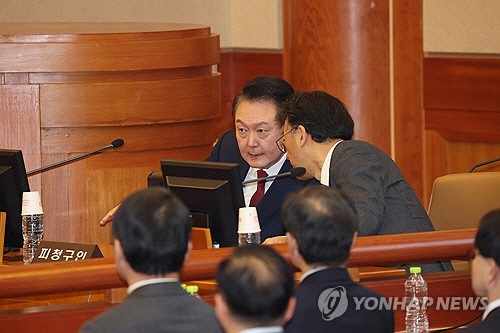윤석열 대통령이 21일 오후 서울 종로구 헌법재판소에서 열리는 탄핵심판 3차 변론에 출석해 변호인과 얘기를 나누고 있다. [연합뉴스]